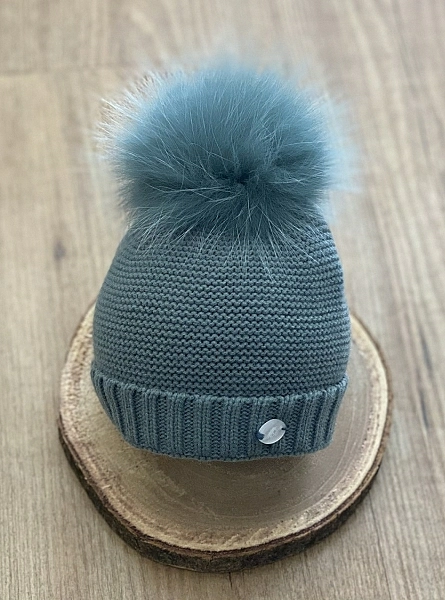 Chubby knit hat in various colors. It wears a natural fur pompom.