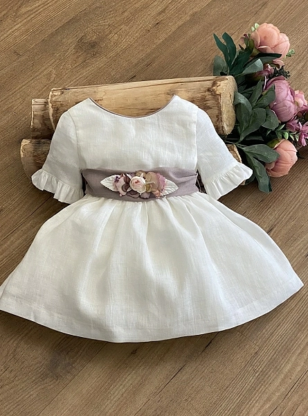 Ecru linen dress with bow and mauve flowers.