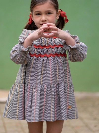 Girl's dress from the Nuez collection, herringbone check pattern with terracotta details Girl's dress from the Nuez collection, herringbone check pattern with terracotta details