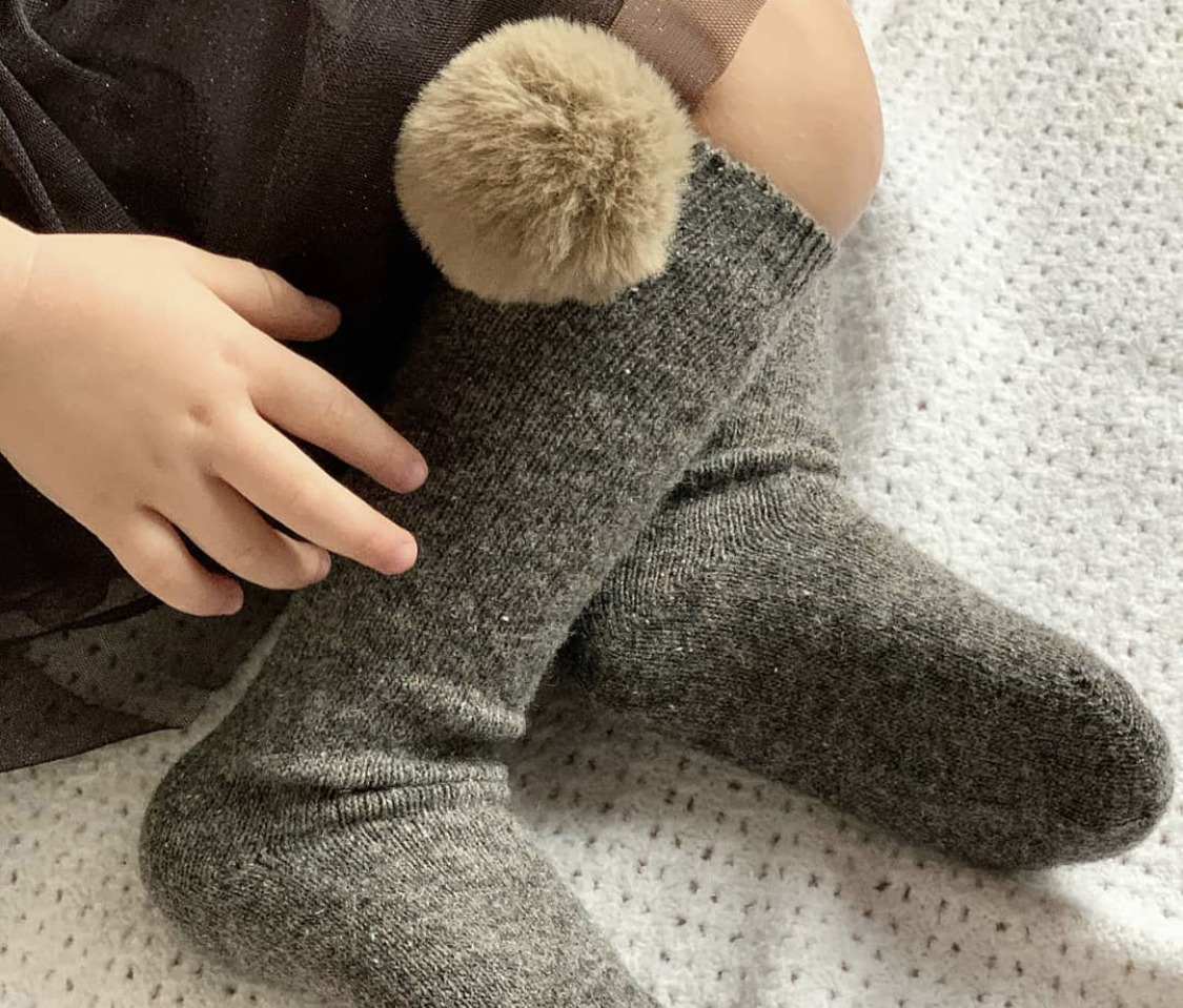 High socks or chubby knit leggings with fur pom pom.